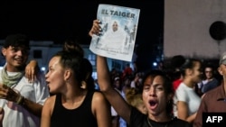 Una mujer cubana sostiene una foto del fallecido José Manuel Carvajal, El Taiger, mientras le rinde homenaje en La Habana el 10 de octubre de 2024. (Foto de YAMIL LAGE / AFP)