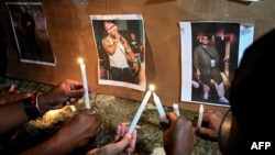 Los cubanos encienden velas junto a fotografías del fallecido cantante de reggaetón José Manuel Carbajal 'El Taiger' mientras le rinden homenaje en La Habana el 10 de octubre de 2024.